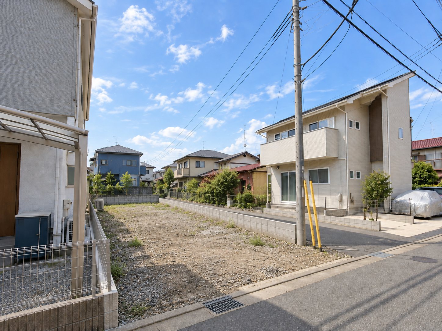 建てる前の土地。住宅に囲まれた、間口が狭く奥に長い敷地
